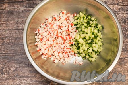 Крабовые палочки достать из упаковки, затем тоже нарезать на мелкие кубики, добавить в миску с огурцами. Желательно, чтобы огурцы и крабовые палочки были нарезаны на кубики примерно одинакового размера, тогда блюдо будет особенно вкусным, потому что не будут выделяться те или иные составляющие салата.