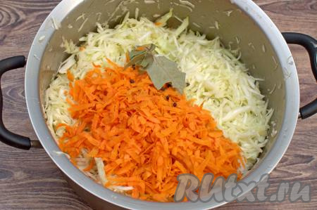Затем к капусте добавить очищенную морковку, натёртую на крупной тёрке, лавровые листья и чёрный молотый перец.