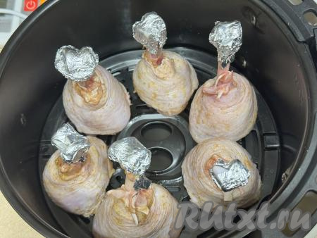 Затем обернуть хрящики небольшими кусочками фольги, чтобы они не сгорели при запекании в аэрогриле. Поставить куриные ножки на решётку аэрогриля, как на фото. Выставить режим 200 градусов и время - 15 минут. Поставить чашу с куриными ножками в аэрогриль. По прошествии 15 минут снизить температуру до 160 градусов и запекать ещё 20 минут.