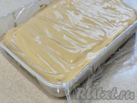 Поверх крема из сгущёнки и сметаны выложить ещё один слой печенья, пропитанного молоком, смазать частью крема. Таким образом, продолжая чередовать слои печенья "Юбилейное", пропитанного молоком, и крема, собрать весь торт без выпечки. Верх торта должен быть смазан кремом. У меня получился торт, состоящий из 4 слоёв печенья, в каждом слое было по 7 печенюшек. Форму с тортом, накрыв его сверху свисающими краями плёнки, поставить в холодильник на ночь.