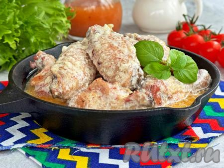 Тушёные куриные крылышки разложить со сковороды по тарелкам и вместе с гарниром, поливая его сливочным соусом, в котором томилось мясо, подать к столу.