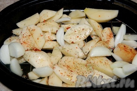 Нарезанные картошку и лук сложить в форму для запекания (я сложила в жаровню), посолить, посыпать специями.
