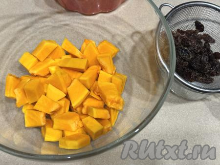 По прошествии 5 минут откинуть изюм на сито, чтобы стекла лишняя вода. Очищенную тыкву нарезать на кубики со стороной 2 сантиметра. Выложить нарезанную тыкву в глубокую миску.&nbsp;