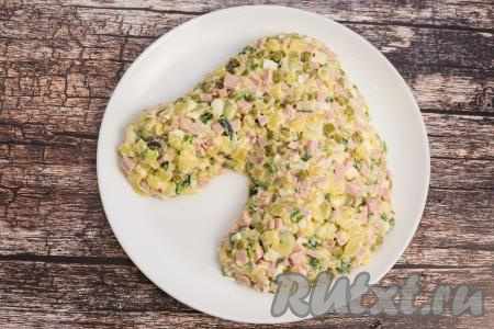 На плоскую большую тарелку выложить салат в виде головы лошади. Немного прижать салат, а по периметру пройтись кулинарной кисточкой, тоже формируя ровный контур лошадиной головы. У меня на формирование головы лошади ушло чуть меньше салата "Оливье", чем я сделала, но тут многое зависит от размера тарелки, на которой вы будете подавать блюдо.