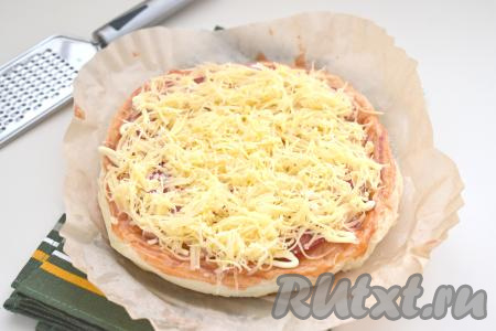 Сверху пиццу покрываем сыром, натёртым на тёрке.