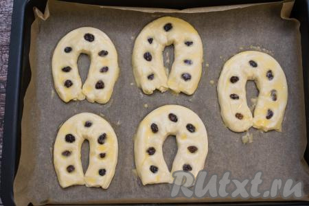 Сырое яйцо в небольшой ёмкости взболтать вилкой до однородности. С помощью силиконовой кисточки смазать поверхность подковок яичной смесью.