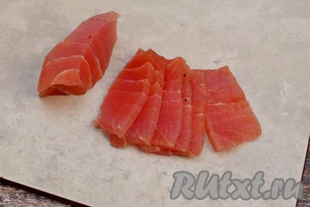 Солёное филе тунца нарезать на тонкие ломтики.