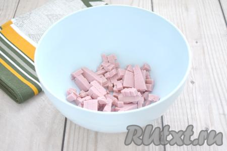 Колбасу нарезаем на маленькие кубики, перекладываем в миску.