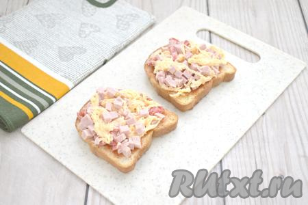 Колбасно-сырную начинку зрительно делим на 4 части. На каждый подсушенный кусок хлеба, смазанный соусом, выкладываем 1/4 часть начинки.