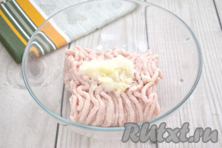 В достаточно объёмную миску выкладываем куриный фарш, добавляем натёртый на крупной тёрке (или пропущенный через мясорубку) лук.