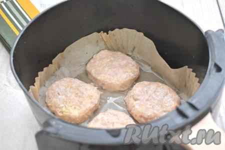 Смачивая руки водой, формируем из каждой части фарша котлету. Застилаем чашу аэрогриля пергаментом. Дополнительно я совсем чуть-чуть смазала пергамент растительным маслом. Выкладываем котлеты из куриного фарша с сыром в чашу аэрогриля (у меня поместились в чашу только 4 котлеты, поэтому я запекала их в два захода).