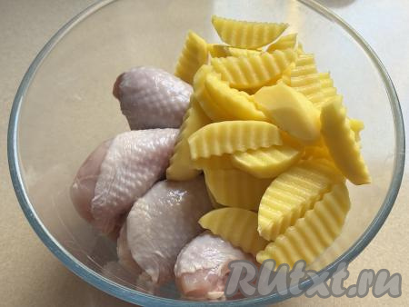 Картошку нарезать на средние дольки примерно одинакового размера (я использовала для нарезки специальный рифлёный нож). В глубокую миску выложить куриные ножки и дольки картофеля.