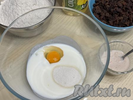 Кефир подогреть в микроволновке в течение 20-30 секунд до комнатной температуры (но можно и просто заранее достать кефир из холодильника, чтобы он успел нагреться до комнатной температуры). В объёмную миску влить кефир комнатной температуры, добавить сырое яйцо и сахар, перемешать смесь венчиком до однородности.