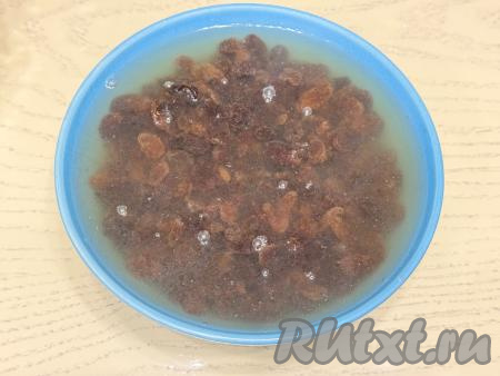 Пока тесто отдыхает, нужно изюм выложить в глубокую тарелку, залить кипящей водой и оставить минут на 5.