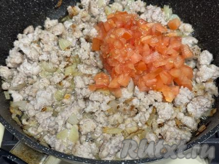 Обжарить фарш с луком в течение 10-12 минут (до изменения цвета), достаточно часто разбивая комочки мяса. Помидор вымыть, по желанию, снять шкурку, мелко нарезать, добавить помидор в сковороду с обжаренным фаршем, перемешать.