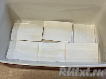 Теперь можно приступать к сборке лазаньи. Для этого на дно прямоугольной формы для запекания (у меня форма размером 23 сантиметра на 15 сантиметров)&nbsp;выложить листы лапши для бешбармака в один слой, стараясь чтобы листы лежали немного внахлёст.