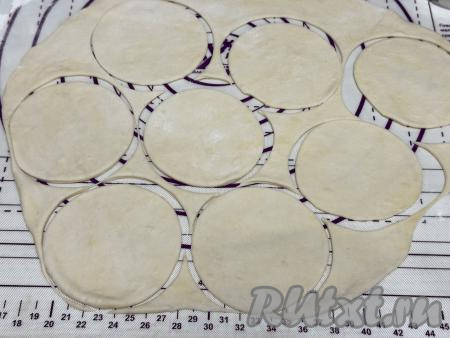"Отдохнувшее" тесто на столе, присыпанном мукой, раскатать в тонкий пласт. С помощью стакана вырезать кружочки диаметром 10 сантиметров.&nbsp;