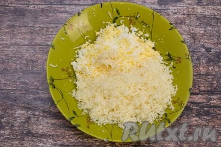 К натёртым яйцам добавить твёрдый (или полутвёрдый) сыр, тоже натёртый на мелкой тёрке, и очищенный чеснок, пропущенный через пресс.