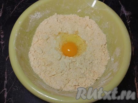 В миску с получившейся крошкой вбить сырое яйцо. Вначале перемешивать тесто столовой ложкой, вмешивая яйцо в крошку.