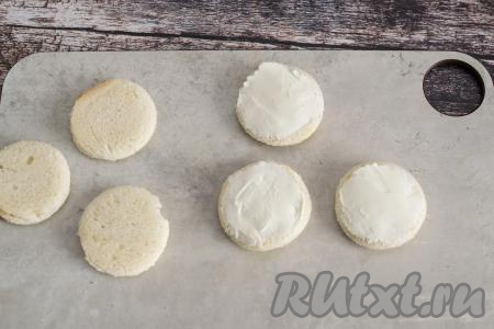 На каждую круглую заготовку из хлеба намазать творожный сыр.