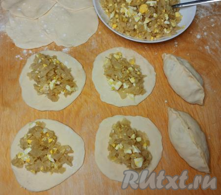 В центр каждой лепёшки выложить примерно 2 столовых ложки начинки из жареной капусты и варёных яиц. Защипнуть края каждой лепёшки над капустой начинкой, формируя пирожки. Таким образом сформировать все 28 пирожков с капустой.