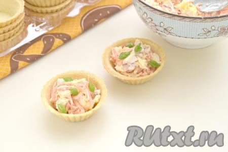 Получившийся салат из копчёной курицы с корейской морковью и сыром непосредственно перед подачей раскладываем по тарталеткам. Количество тарталеток, которое вы заполните получившимся салатом, зависит от размера тарталеток (всего я заполнила салатом 7 тарталеток). По желанию, закуску можно украсить мелко нарезанной зеленью (я посыпала нарезанным зелёным луком).