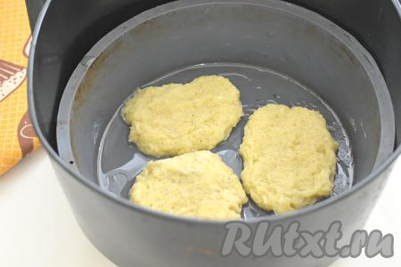 Готовить драники лучше в силиконовой форме (если нет силиконовой формы, можно застелить чашу аэрогриля пергаментом, застилая и дно, и формируя небольшие бортики из бумаги). Силиконовую форму нужно поставить в чашу аэрогриля, предварительно убрав из чаши решётку. Смазываем форму (или пергамент) растительным маслом. Выкладываем по 1-1,5 столовых ложек картофельного теста в подготовленную силиконовую форму (или на пергамент) и отравляем в аэрогриль.