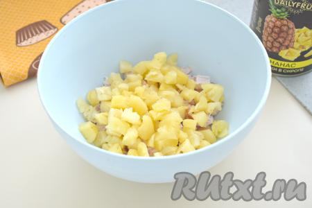 Консервированные ананасы тоже нарезаем на небольшие кубики, добавляем в миску с копчёной курицей.