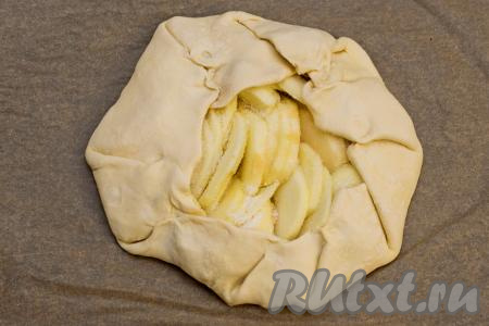 Свободные края теста подвернуть на начинку, старясь скрепить слоёное тесто в местах изгибов, чтобы оно не разворачивалось во время выпечки. Получится заготовка галеты с яблоками, как на фото.