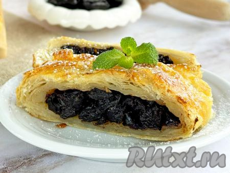 Готовую выпечку достать из духовки, слегка остудить, нарезать на кусочки и подать к столу. Сочетание большого количества начинки из чернослива и воздушного слоёного теста делает этот пирог сочным и очень вкусным.
