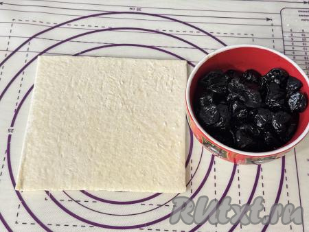 Подготовить продукты для приготовления слоёного пирога с черносливом. Разморозить пласт слоёного теста при комнатной температуре. Слоёное тесто для этой выпечки можно взять как бездрожжевое (из него я и готовила), так и дрожжевое. Чернослив промыть под проточной водой, затем обдать хорошо кипятком, после этого разложить на бумажном полотенце, дать обсохнуть.