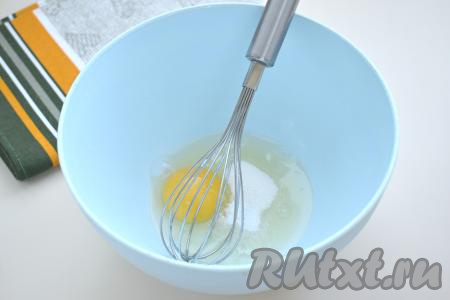 Прежде всего замесим блинное тесто, для этого разбиваем в достаточно глубокую миску сырое яйцо, всыпаем к нему сахар и соль, перемешиваем яичную смесь венчиком до однородности.