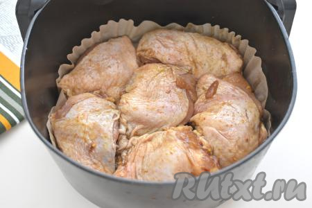 Застилаем чашу аэрогриля пергаментом, выкладываем куриные бёдра, замаринованные в соевом соусе. Отправляем чашу в аэрогриль, устанавливаем температуру на 200 градусов, время - на 35 минут (мощность аэрогриля у меня - 1400 Ватт).