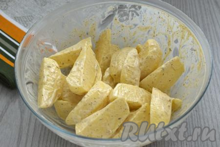 Тщательно перемешиваем ломтики картошки, равномерно покрывая их майонезом, маслом, солью и специями со всех сторон.&nbsp;
