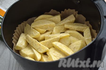 Застилаем чашу аэрогриля пергаментом. Выкладываем в аэрогриль ломтики картошки, покрытые майонезом. Отправляем чашу в аэрогриль. Включаем аэрогриль на 180 градусов, время устанавливаем на 35-40 минут.