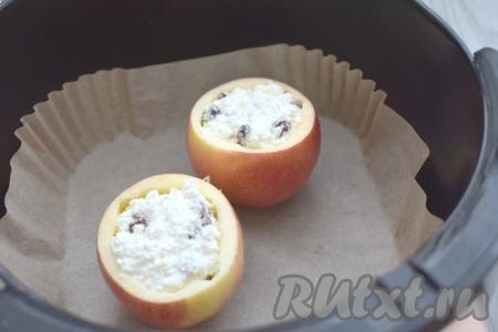 Застилаем чашу аэрогриля пергаментом. Яблоки заполняем получившейся творожной массой и ставим в чашу аэрогриля. Отправляем чашу с яблоками в аэрогриль.