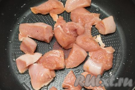 На сковороде разогреть растительное масло, затем выложить кусочки мяса курицы.