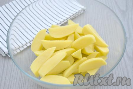 Очищаем картофель, нарезаем его на примерно одинаковые ломтики и складываем в миску.