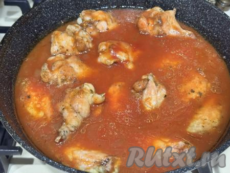 Ещё раз перевернуть куриные крылья на сковороде. Влить томатный соус в сковороду с обжаренными крылышками. Желательно, чтобы соус практически полностью покрывал крылья, поэтому, если необходимо, добавьте ещё немного воды.