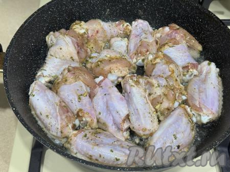 Хорошо прогреть растительное масло в сковороде, выложить в один слой куриные крылышки.&nbsp;