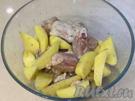 Хорошо перемешать картошку с частями курицы, покрывая их маслом и специями со всех сторон.&nbsp;