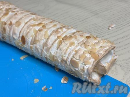 Меренговый корж с мандаринами аккуратно свернуть в плотный рулет, помогая себе ковриком (или пергаментом).