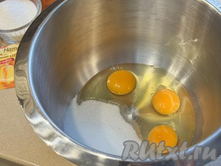 Прежде всего замесим песочное тесто для шарлотки. Для этого в чашу миксера нужно вбить сырые яйца, всыпать сахар. На максимальных оборотах миксера взбить яйца с сахаром в течение 6-7 минут. В процессе взбивания масса должна стать более светлой, увеличиться в объёме.