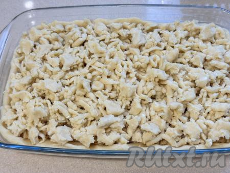 Вторую часть теста достать из морозилки, натереть на крупной тёрке и равномерно выложить поверх начинки.&nbsp;