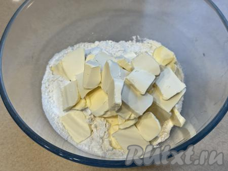 В отдельную достаточно объёмную миску всыпать 350 грамм муки и весь разрыхлитель. Маргарин (или сливочное масло) достать из холодильника, нарезать на кусочки, добавить в миску с мукой и разрыхлителем, перетереть массу руками до получения мелкой, однородной песочной крошки.&nbsp;