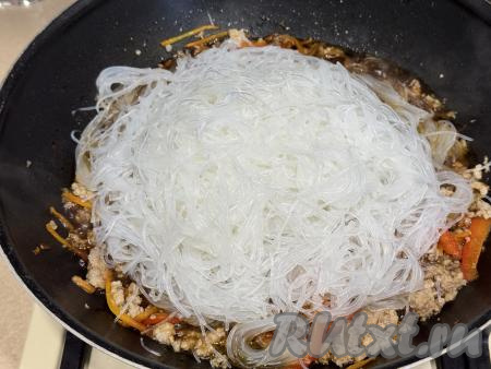 Фунчозу нарезать ножницами на части, затем выложить в сковороду с овощами и фаршем.