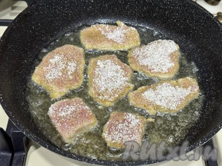 В сковороду влить растительное масло, хорошо его разогреть, выложить заготовки наггетсов из свинины, жарить их на среднем огне минуты 3-4 (до подрумянивания снизу).