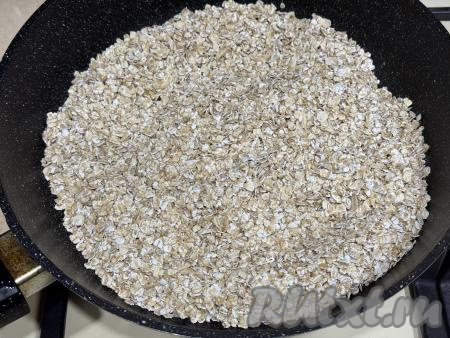 На сухую сковороду (смазывать сковороду маслом не нужно) выложить овсяные хлопья.