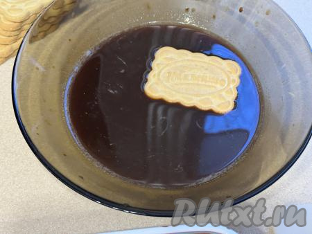 Остывший кофе влить в достаточно глубокую тарелку. Каждое печенье полностью окунать в кофе.