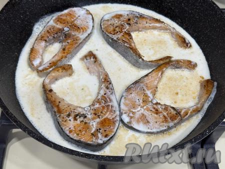 После того как стейки обжарятся с двух сторон, влить в сковороду сливки. Довести сливки до кипения, сразу же убавить огонь до минимума. Накрыть сковороду крышкой.&nbsp;